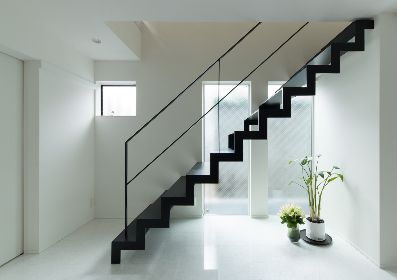 壁と床が白い廊下にある黒いアイアンのスケルトン階段・デザイン住宅 注文住宅・デザイン住宅建築実例_『CASE579 Functional House』_階段
