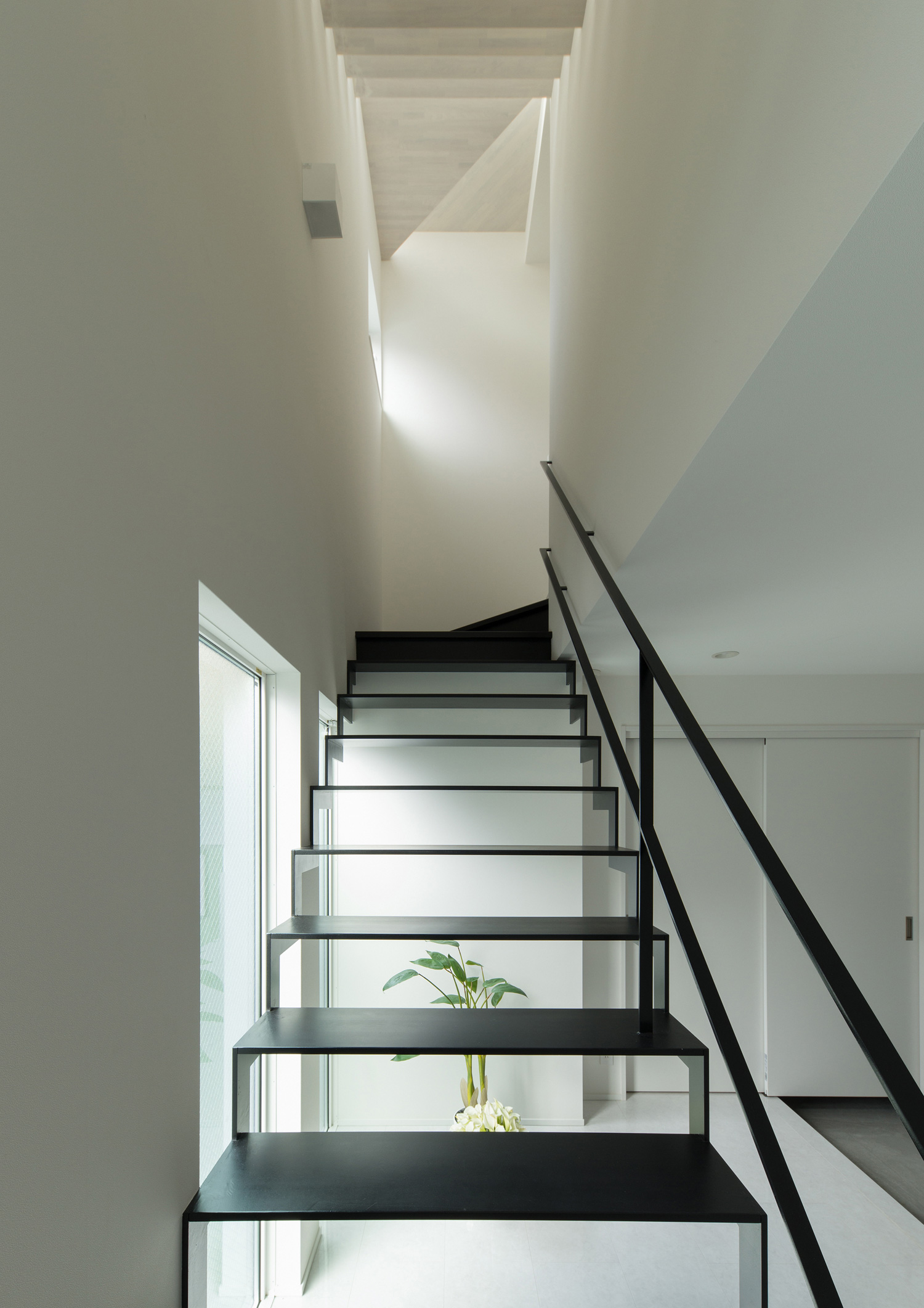 階段越しに観葉植物が見える、窓に面した黒いスケルトン階段・デザイン住宅 注文住宅・デザイン住宅建築実例_『CASE579 Functional House』_階段
