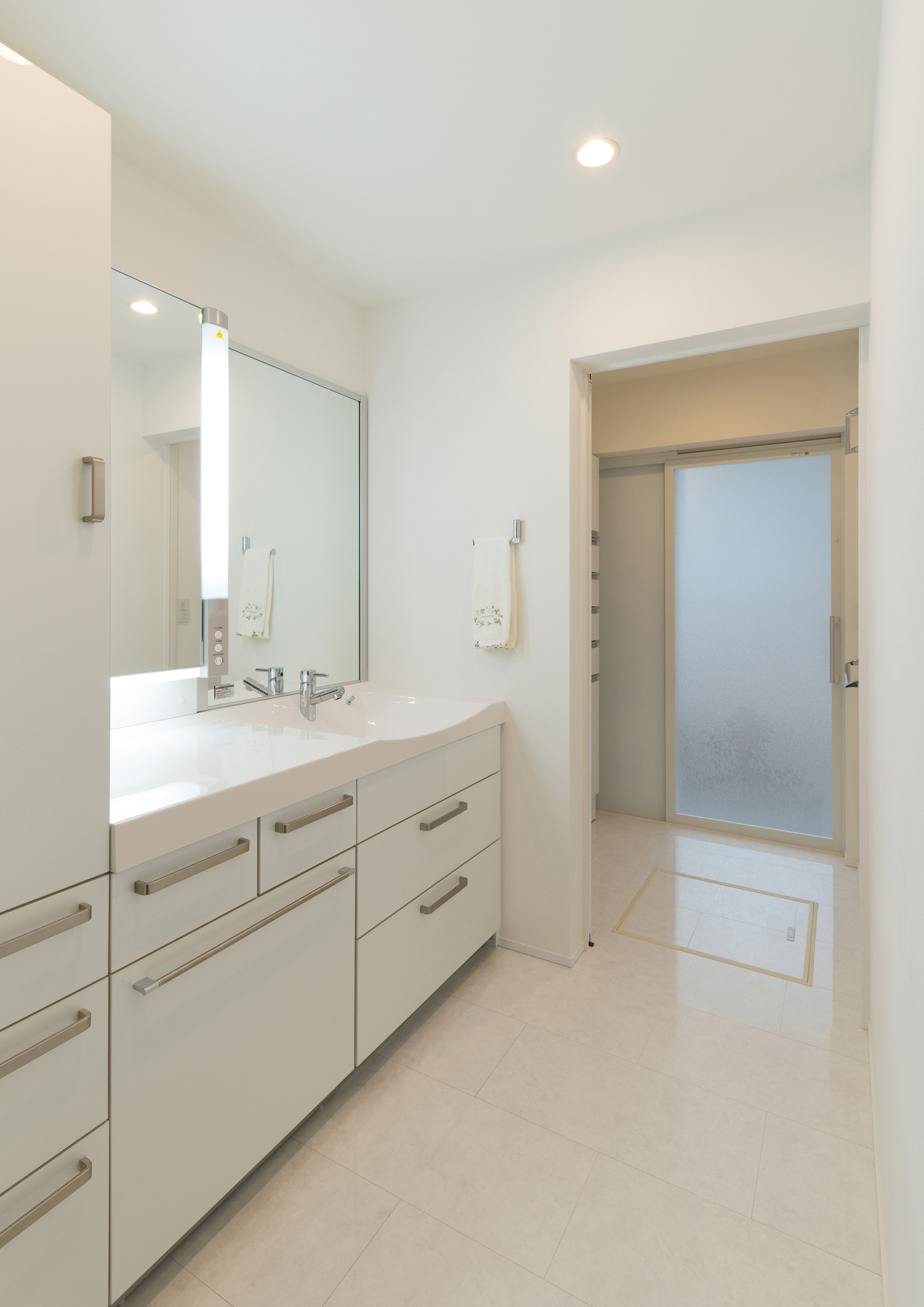 脱衣所と引き戸で仕切られた白を基調とした洗面所・デザイン住宅 注文住宅・デザイン住宅建築実例_『CASE579 Functional House』_浴室・洗面所