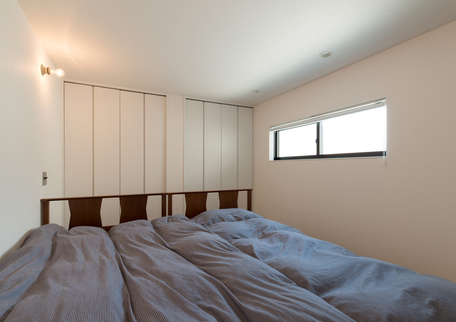 スリット窓があるネイビーのベッドを置いた寝室・デザイン住宅 注文住宅・デザイン住宅建築実例_『CASE582 大切な時を刻む家』_寝室