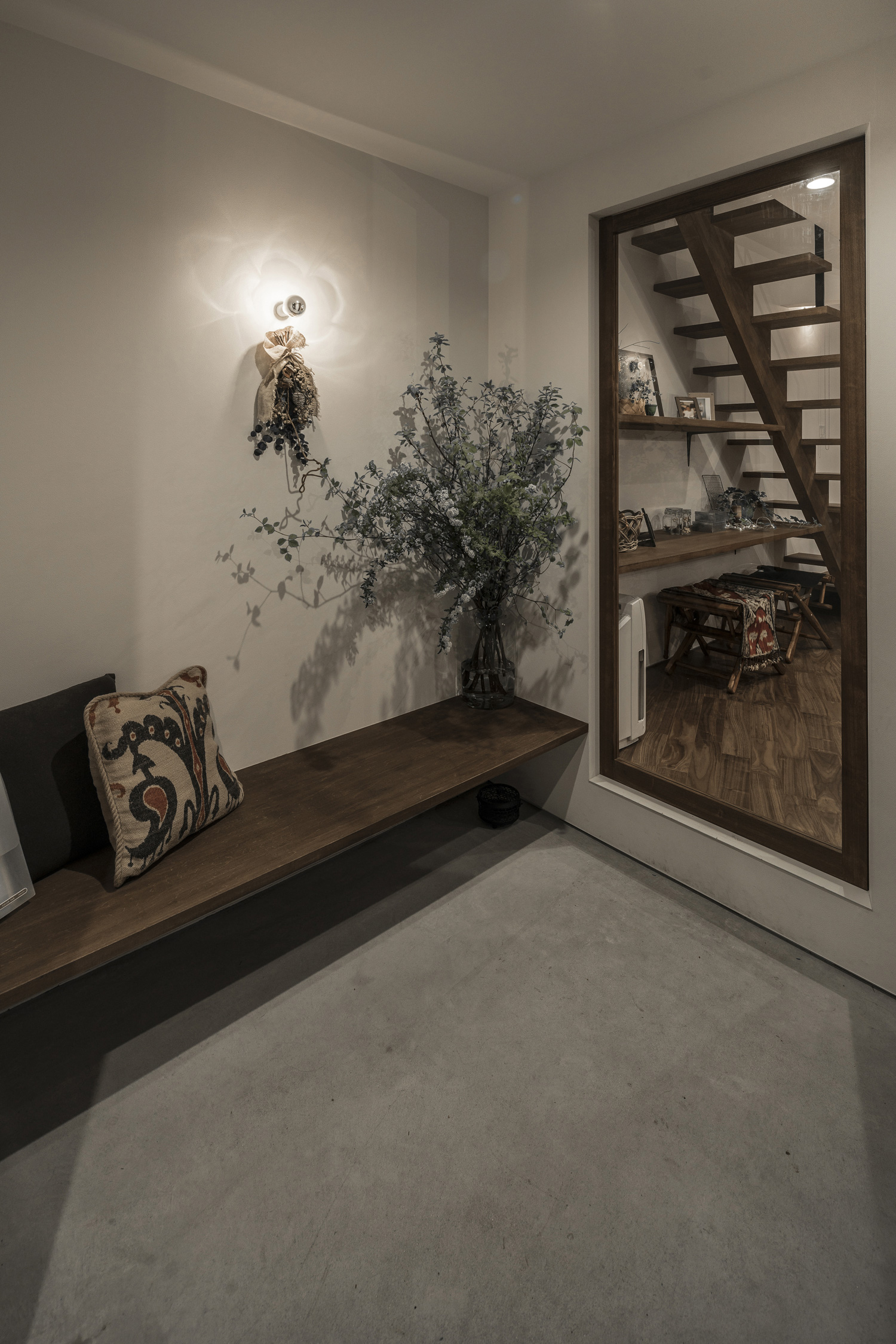 壁に間接照明が取り付けられた造作ベンチのあるモルタルの玄関・デザイン住宅 注文住宅・デザイン住宅建築実例_『CASE583 デルタ』_玄関