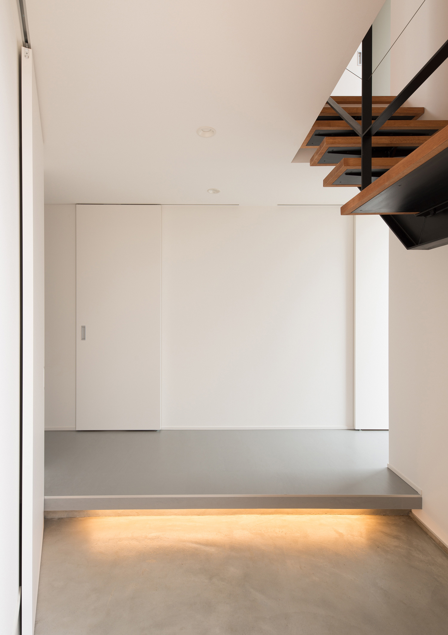 足元に間接照明を取り付けたモルタルの玄関・デザイン住宅 注文住宅・デザイン住宅建築実例_『CASE584 ソラノスキマ』_玄関