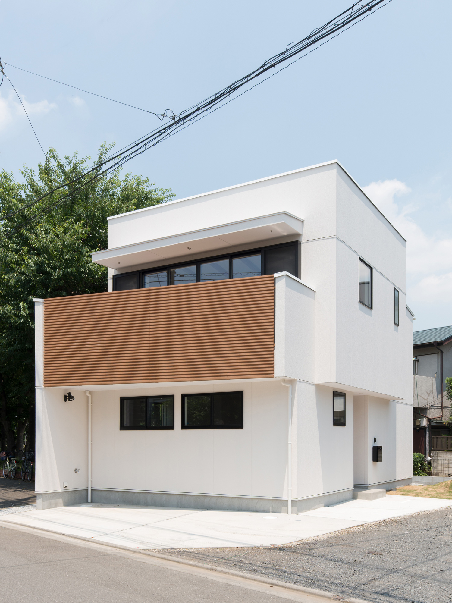 白い外壁で木のルーバー付きのバルコニーがある家・デザイン住宅 注文住宅・デザイン住宅建築実例_『CASE586 サクラクリヒノキ』_外観