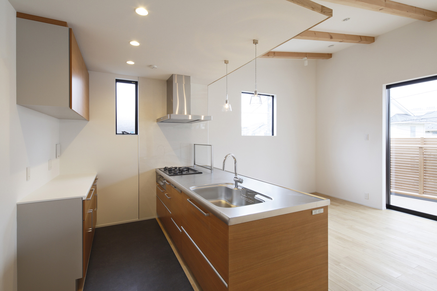 下がり天井でペンダントライトが取り付けられた木目のペニンシュラキッチン・デザイン住宅 注文住宅・デザイン住宅建築実例_『CASE586 サクラクリヒノキ』_キッチン