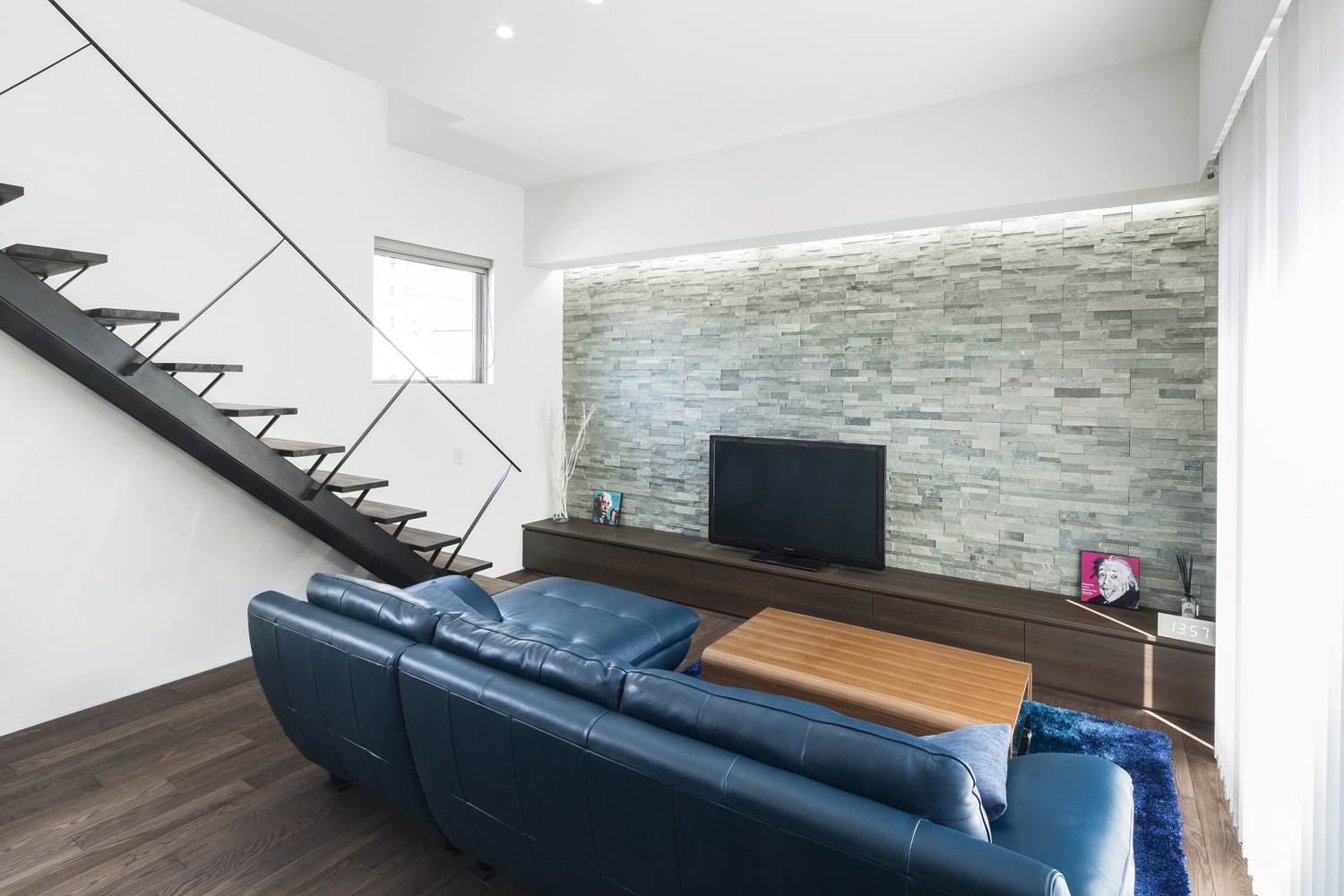 青いソファーがテレビの前に置かれたリビングイン階段のあるLDK・デザイン住宅 注文住宅・デザイン住宅建築実例_『CASE587 Nero』_LDK