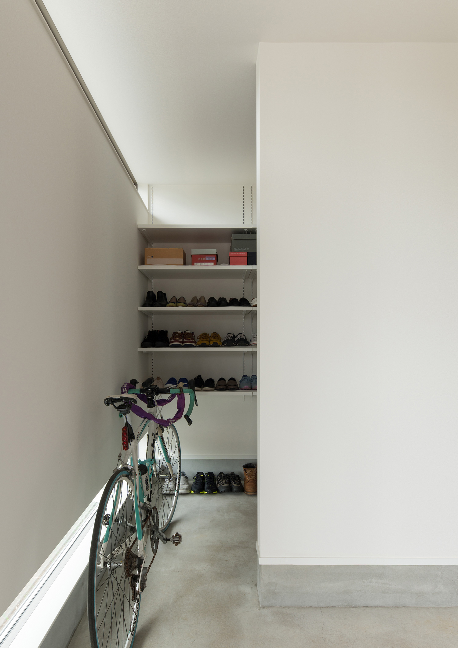 自転車を置くスペースがあるモルタルの玄関・デザイン住宅 注文住宅・デザイン住宅建築実例_『CASE588 涅の櫂』_玄関