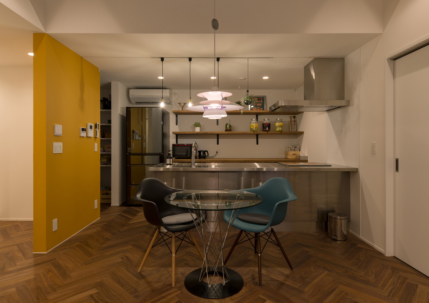 ペンダントライトに照らされたステンレスのペニンシュラキッチンとダイニングテーブル・デザイン住宅 注文住宅・デザイン住宅建築実例_『CASE588 涅の櫂』_LDK