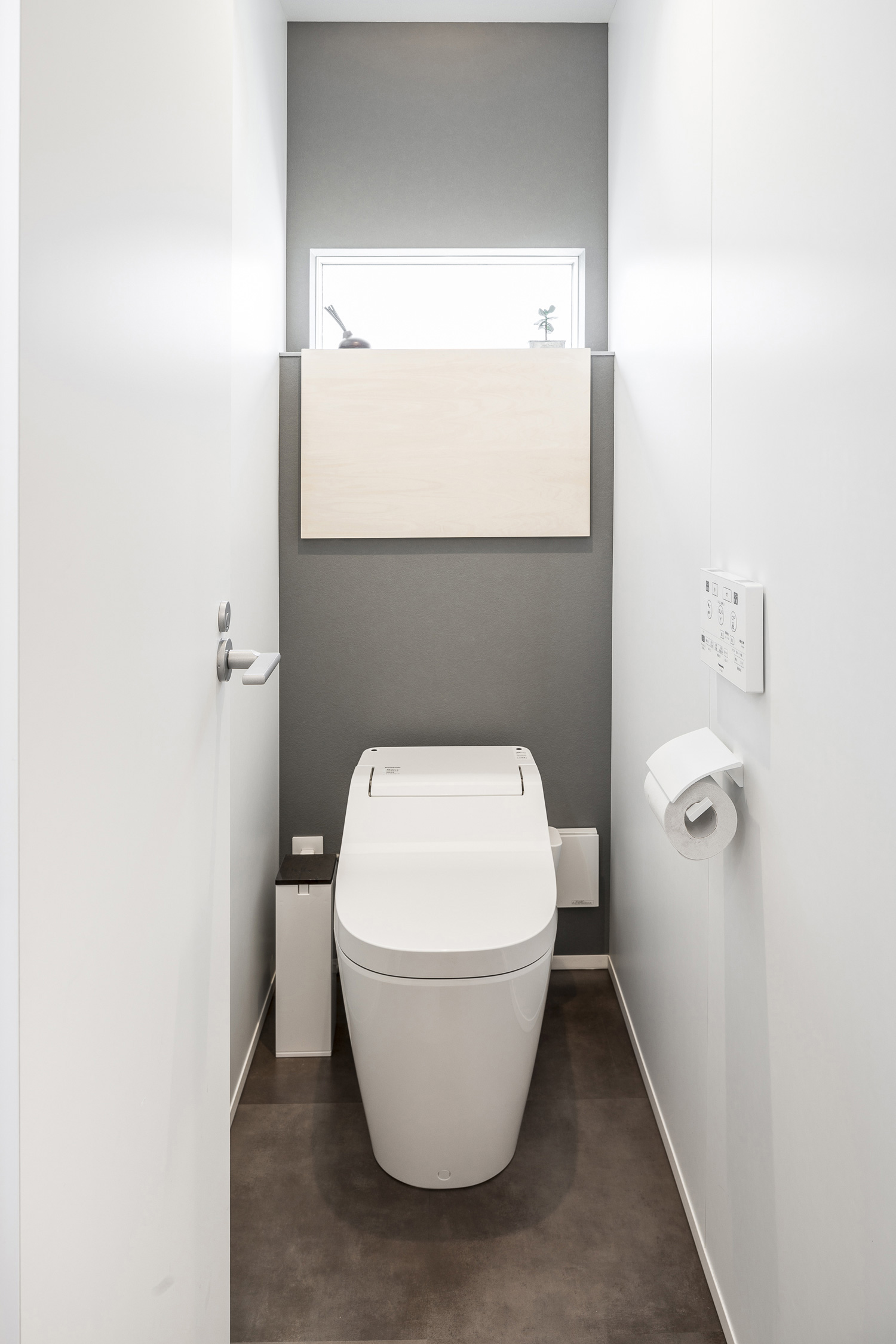 グレーのアクセントクロスが設けられた、スリット窓や収納ボックスがあるトイレ・デザイン住宅 注文住宅・デザイン住宅建築実例_『CASE589 pinwheel』_トイレ