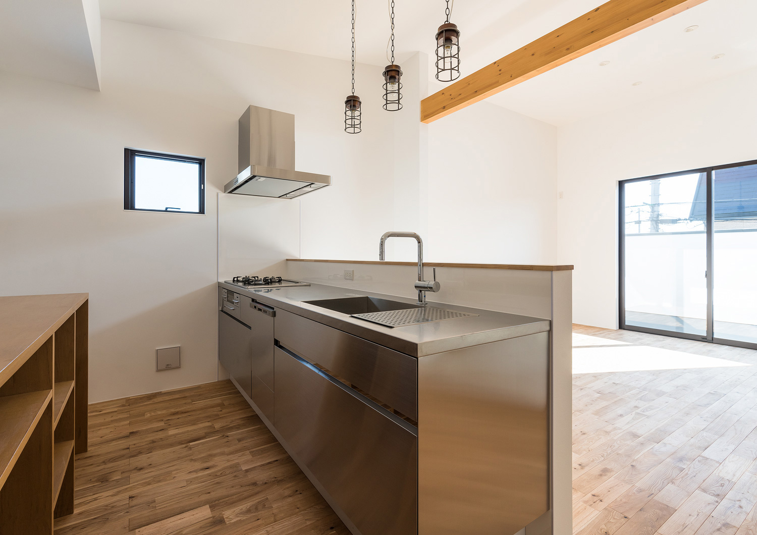 正面にバルコニーに面した窓がある腰壁付きのキッチン・デザイン住宅 注文住宅・デザイン住宅建築実例_『CASE590 つなぐ家』_キッチン