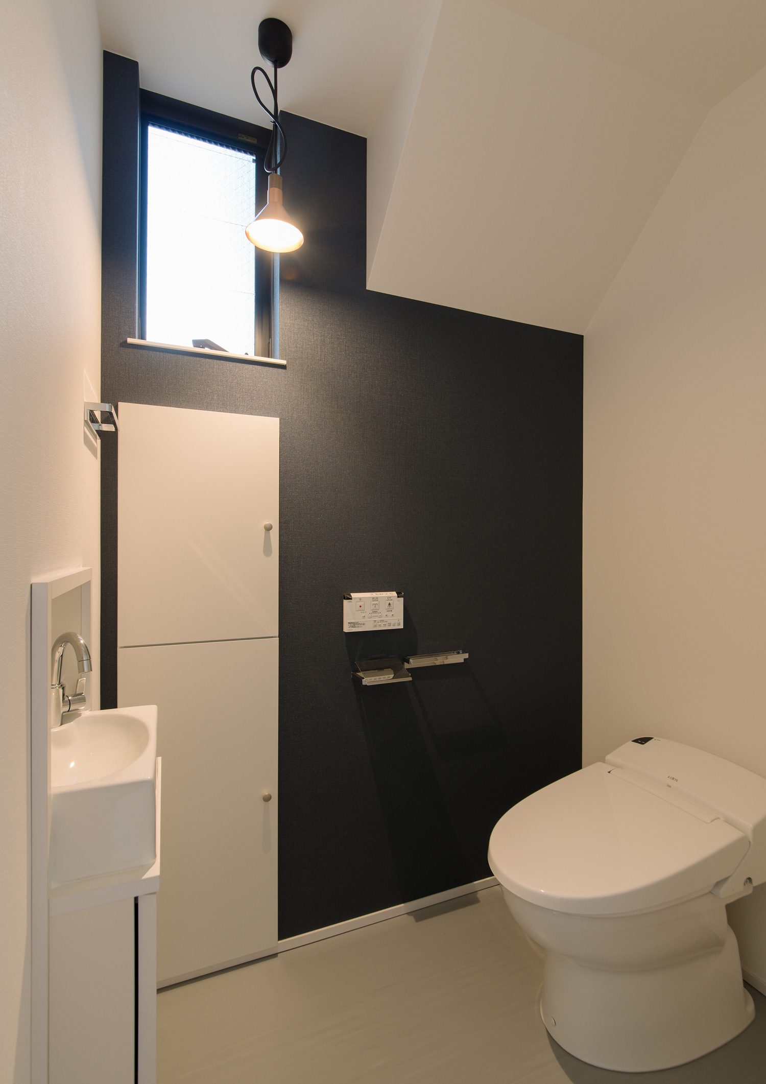 黒いアクセントクロスがある、扉付きの収納や薄型手洗いがあるトイレ・デザイン住宅 注文住宅・デザイン住宅建築実例_『CASE595 あかりを織る家』_トイレ