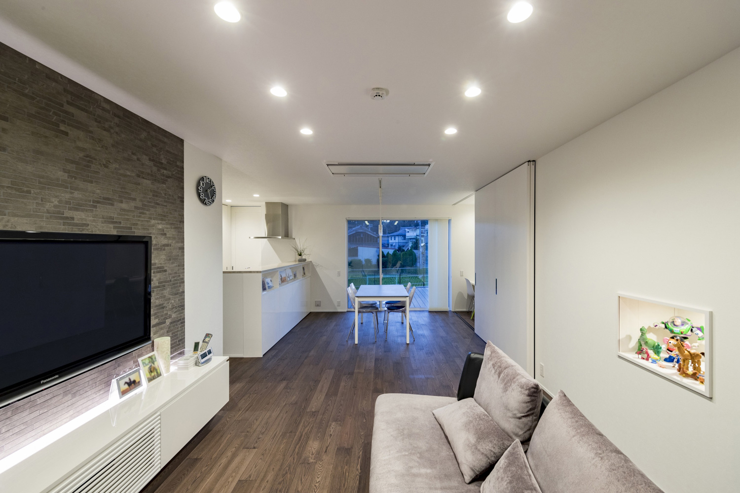 ベランダに面した窓があるグレーのフローリングのLDK・デザイン住宅 注文住宅・デザイン住宅建築実例_『CASE598 爽 ~風と光~』_LDK