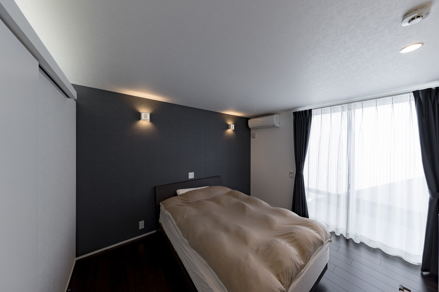 黒いアクセントクロスに間接照明が取り付けられた、大きな窓のある寝室・デザイン住宅 注文住宅・デザイン住宅建築実例_『CASE598 爽 ~風と光~』_寝室