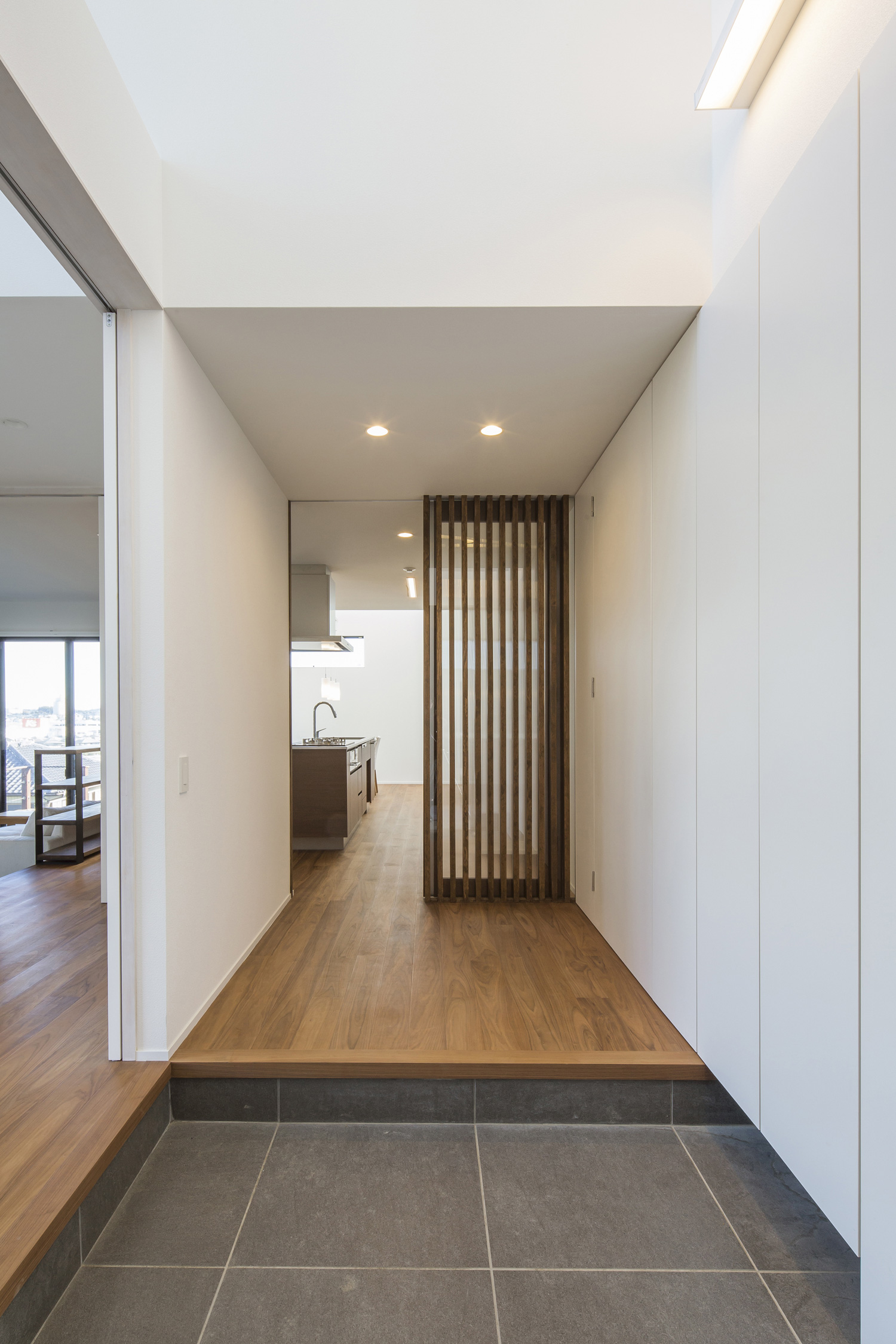 吹き抜けになった、LDKと繋がるタイル貼りの玄関・デザイン住宅 注文住宅・デザイン住宅建築実例_『CASE600 ソラの家』_玄関