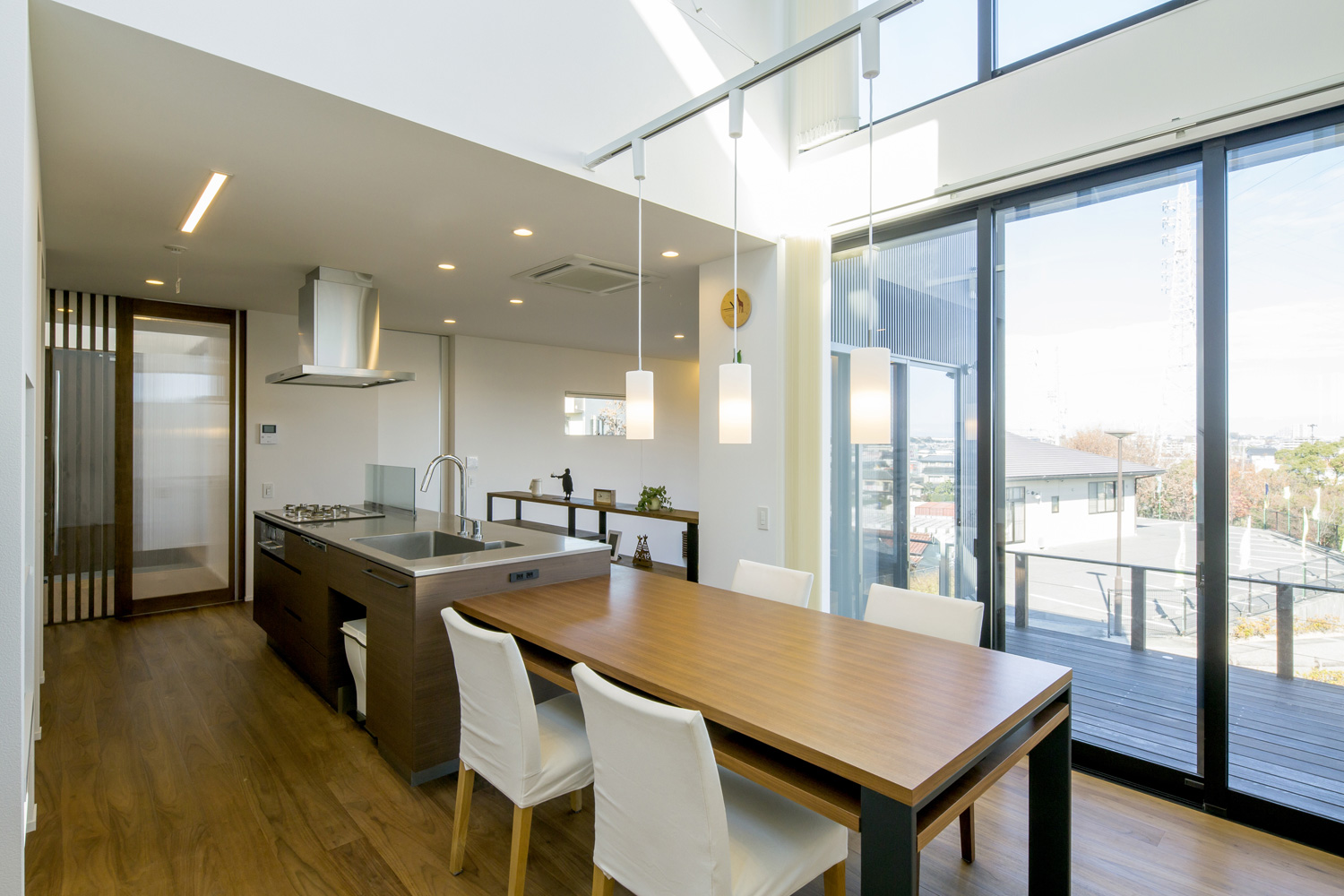 アイランドキッチンとダイニングテーブルが横並びになった大開口窓があるLDK・デザイン住宅 注文住宅・デザイン住宅建築実例_『CASE600 ソラの家』_LDK