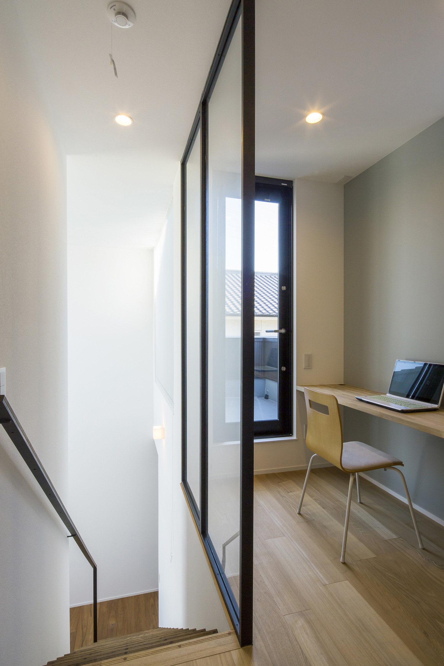 階段部分とガラスで仕切られた壁付けデスクのある廊下・デザイン住宅 注文住宅・デザイン住宅建築実例_『CASE600 ソラの家』_書斎