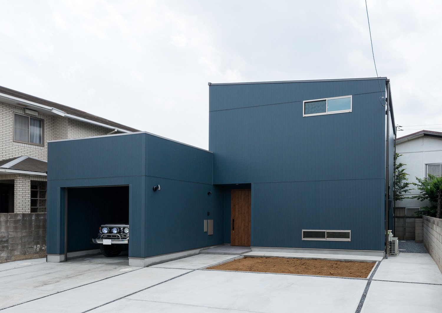 青い外壁でスリット窓が取り付けられているガレージ付きの家・デザイン住宅 注文住宅・デザイン住宅建築実例_『CASE601 ドマノイエ』_外観