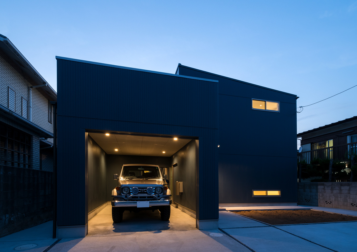 車が一台収納された、照明付きのガレージ・デザイン住宅 注文住宅・デザイン住宅建築実例_『CASE601 ドマノイエ』_外観