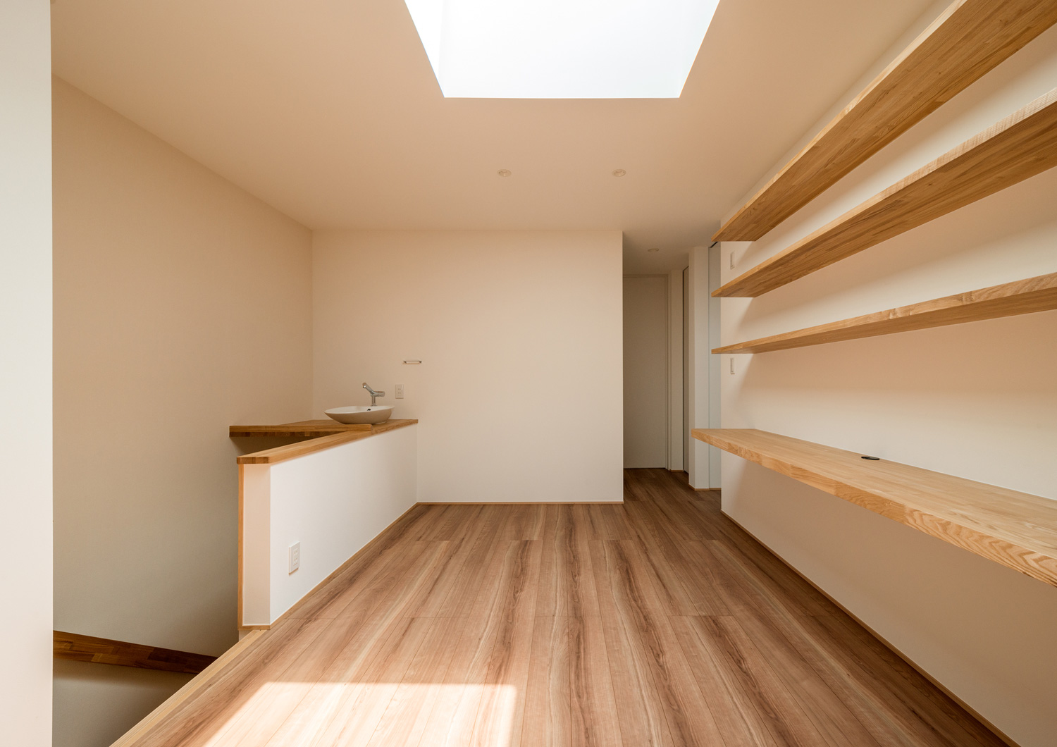 壁付けデスクと壁付け棚を設けた天窓のあるホール・デザイン住宅 注文住宅・デザイン住宅建築実例_『CASE601 ドマノイエ』_フリースペース