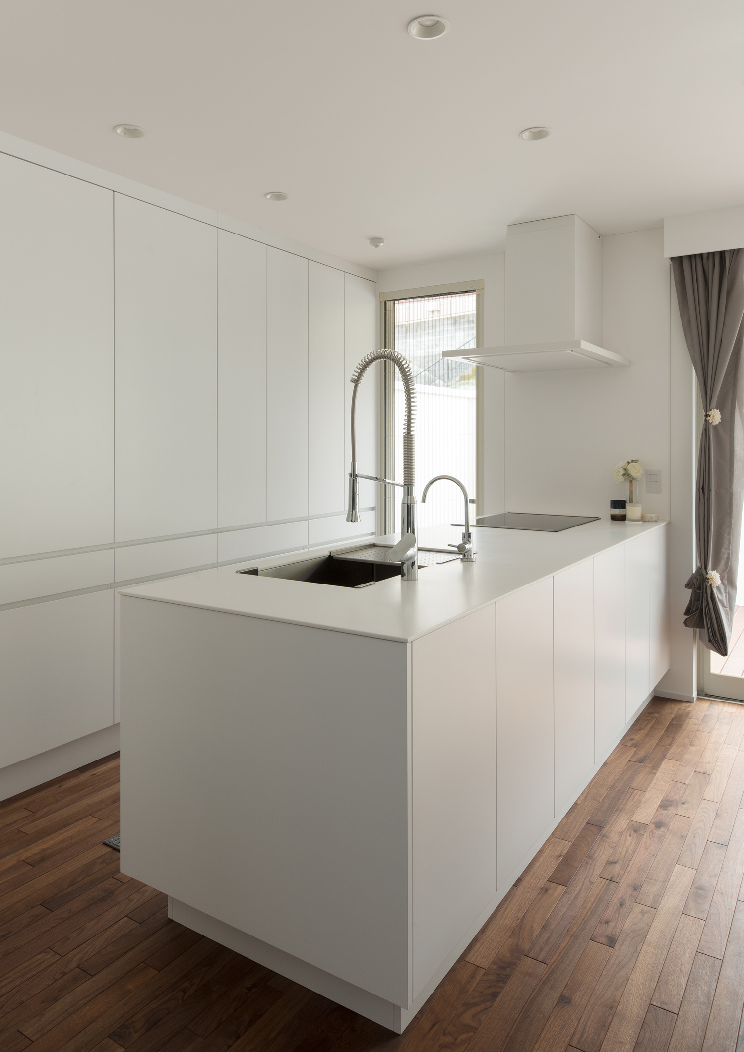 背面のカップボードに白い扉を取り付けた白いペニンシュラキッチン・デザイン住宅 注文住宅・デザイン住宅建築実例_『CASE602 WOODボックスハウス』_キッチン