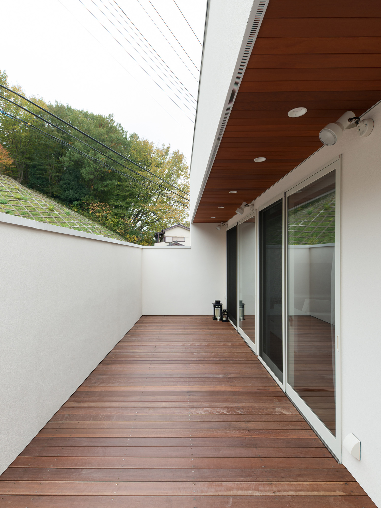 白い目隠し壁がある木目の軒天井のバルコニー・デザイン住宅 注文住宅・デザイン住宅建築実例_『CASE602 WOODボックスハウス』_テラス・バルコニー