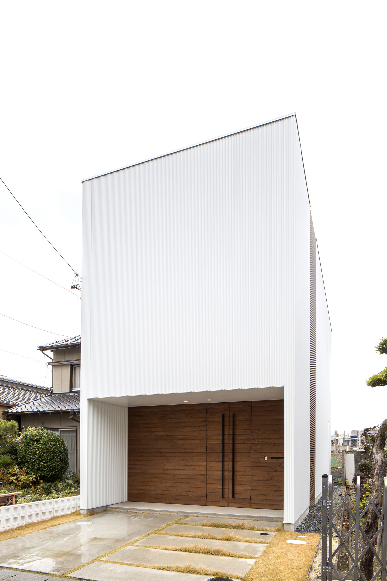 窓がない、エントランスの壁を木目とした白いキューブ状の家・デザイン住宅 注文住宅・デザイン住宅建築実例_『CASE603 Flügel』_外観