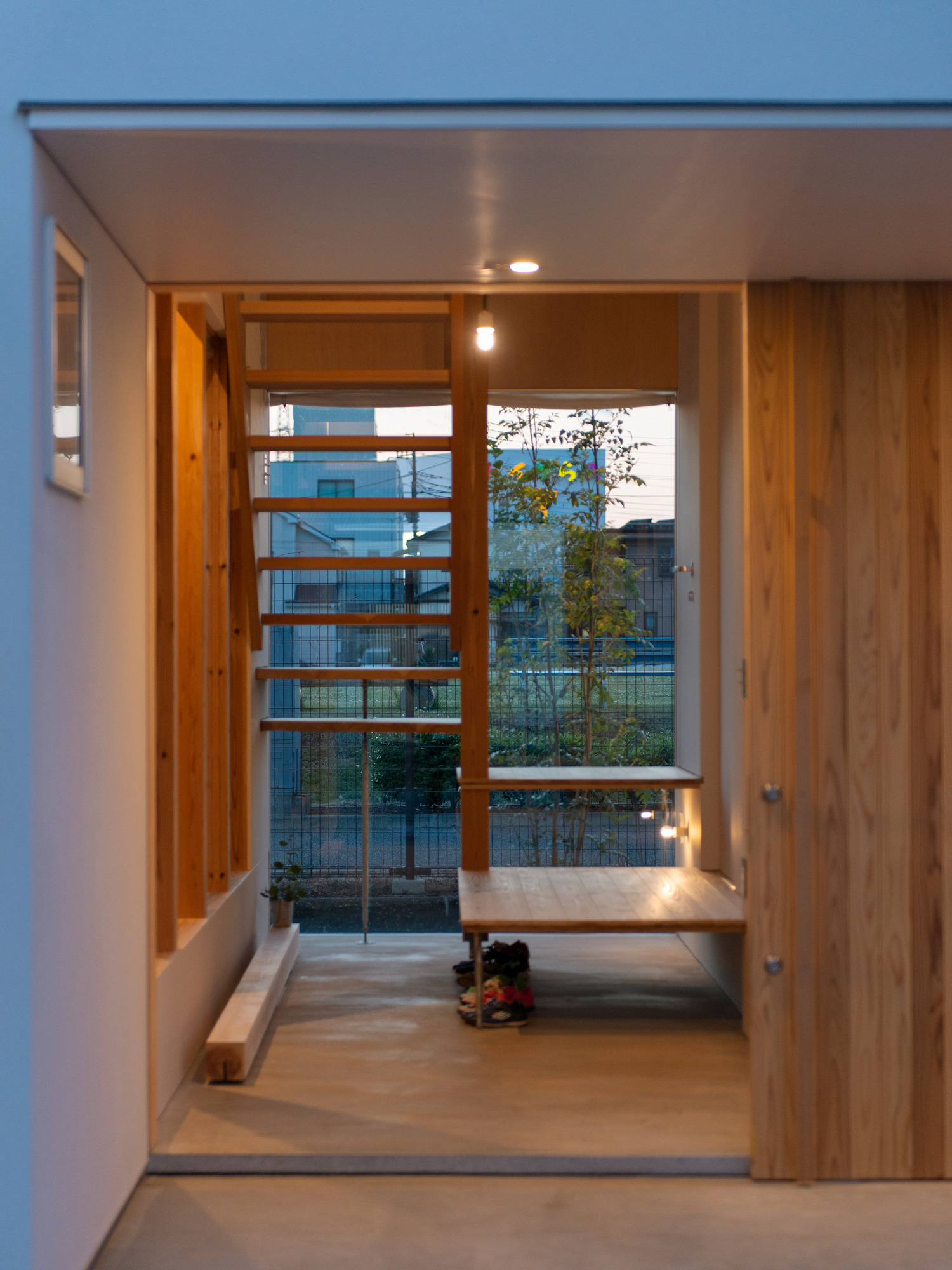 正面に窓と木製のスケルトン階段がある土間の玄関・デザイン住宅 注文住宅・デザイン住宅建築実例_『CASE605 切妻のsign』_玄関