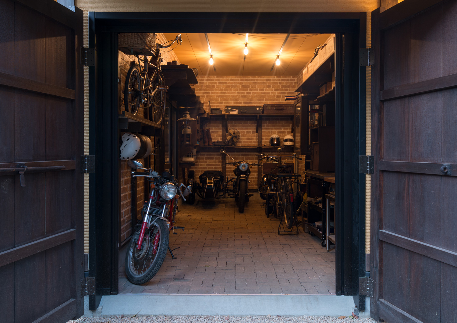 レンガ風の壁紙を貼った扉付きのガレージ・デザイン住宅 注文住宅・デザイン住宅建築実例_『CASE607 懐(ふところ)』_ガレージ