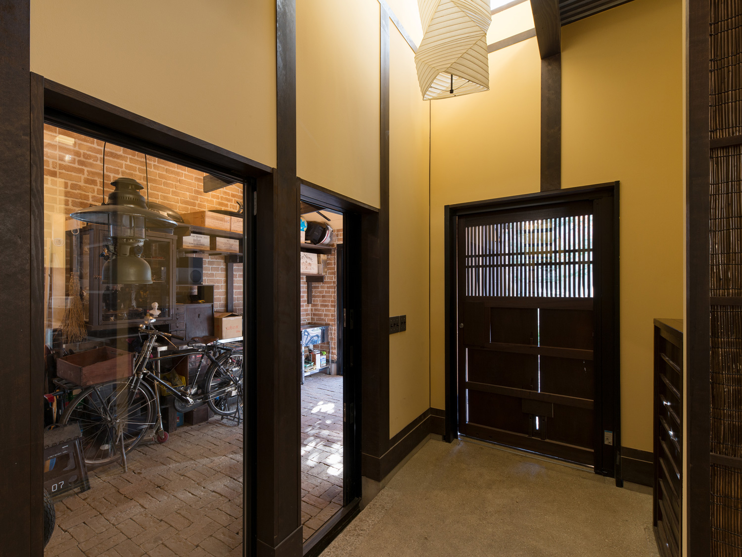 ガラス越しにガレージが見える吹き抜けの土間玄関・デザイン住宅 注文住宅・デザイン住宅建築実例_『CASE607 懐(ふところ)』_玄関