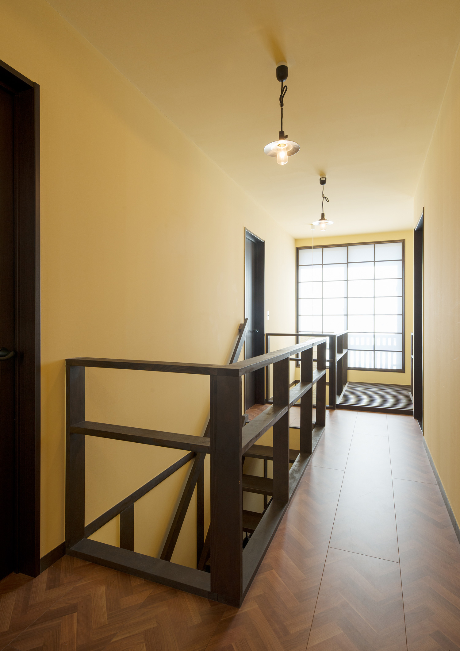 吹き抜けに面した、ヘリンボーン柄の床で黄色い壁の廊下・デザイン住宅 注文住宅・デザイン住宅建築実例_『CASE607 懐(ふところ)』_廊下