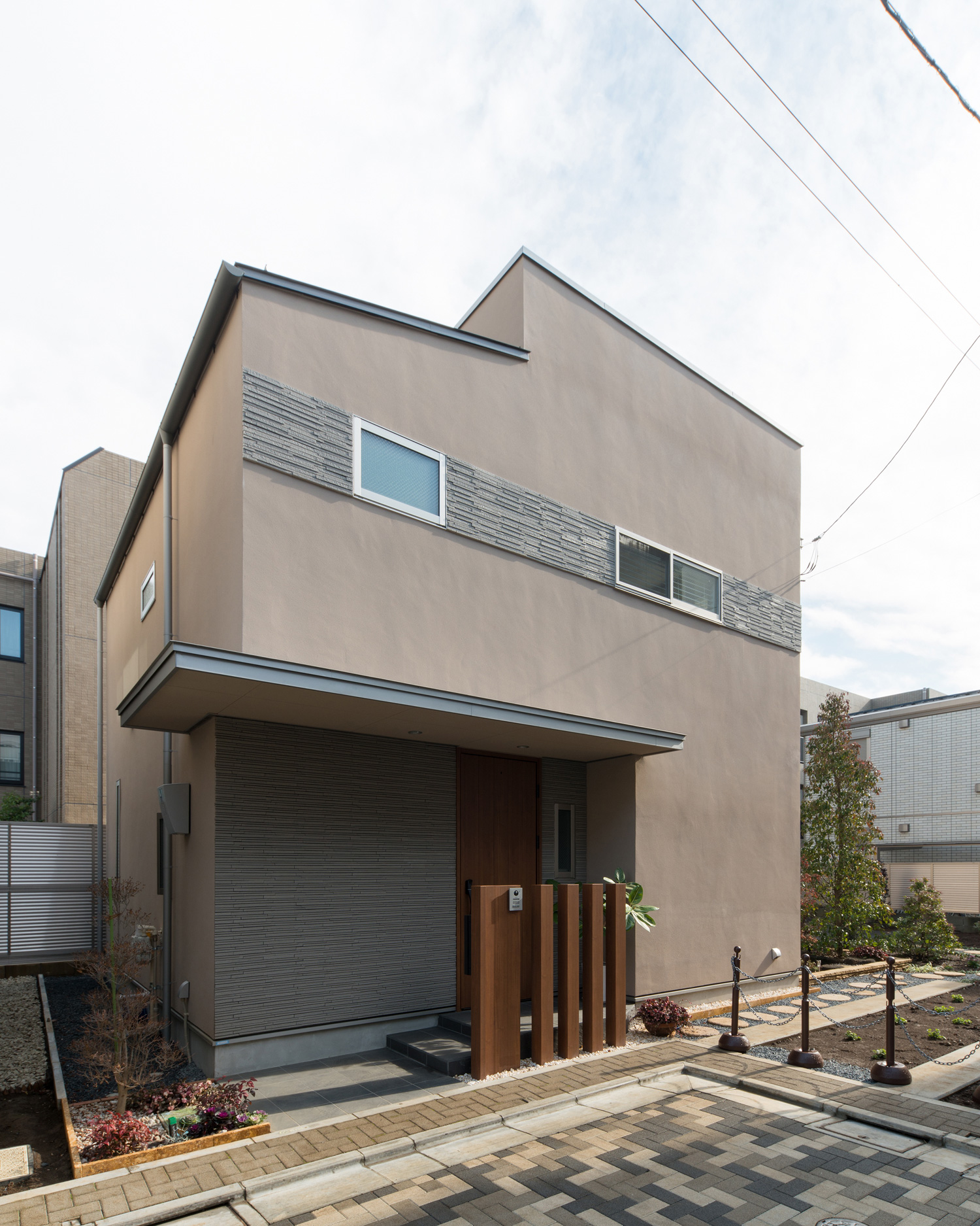 玄関の庇が張り出しているベージュの外壁の家・デザイン住宅 注文住宅・デザイン住宅建築実例_『CASE608 和みの住処』_外観