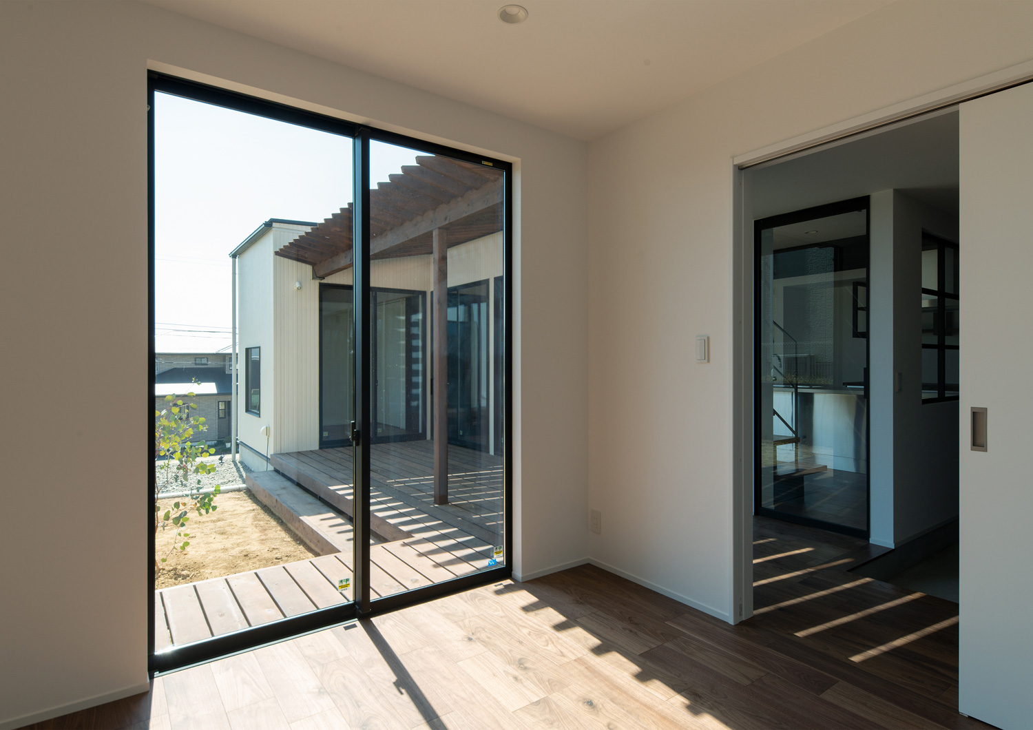 窓からパーゴラのあるウッドデッキが見える寝室・デザイン住宅 注文住宅・デザイン住宅建築実例_『CASE609 パーゴラの家』_寝室