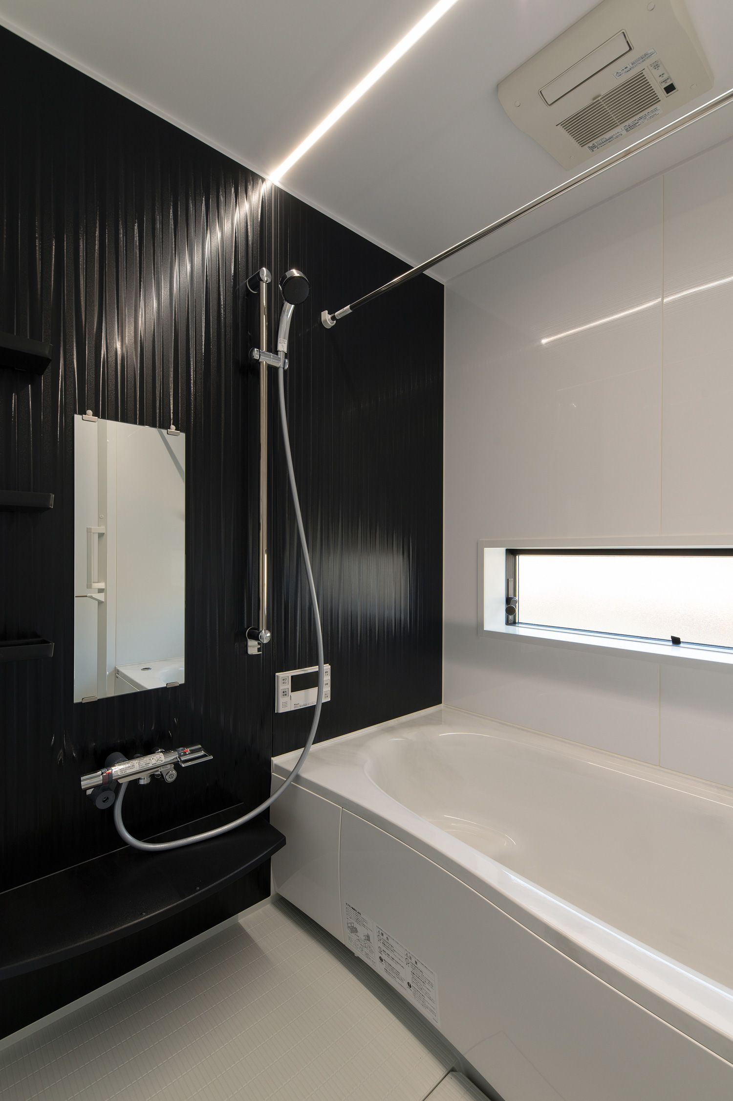 一部分だけ黒い壁となった横長のスリット窓がある浴室・デザイン住宅 注文住宅・デザイン住宅建築実例_『CASE609 パーゴラの家』_浴室・洗面所