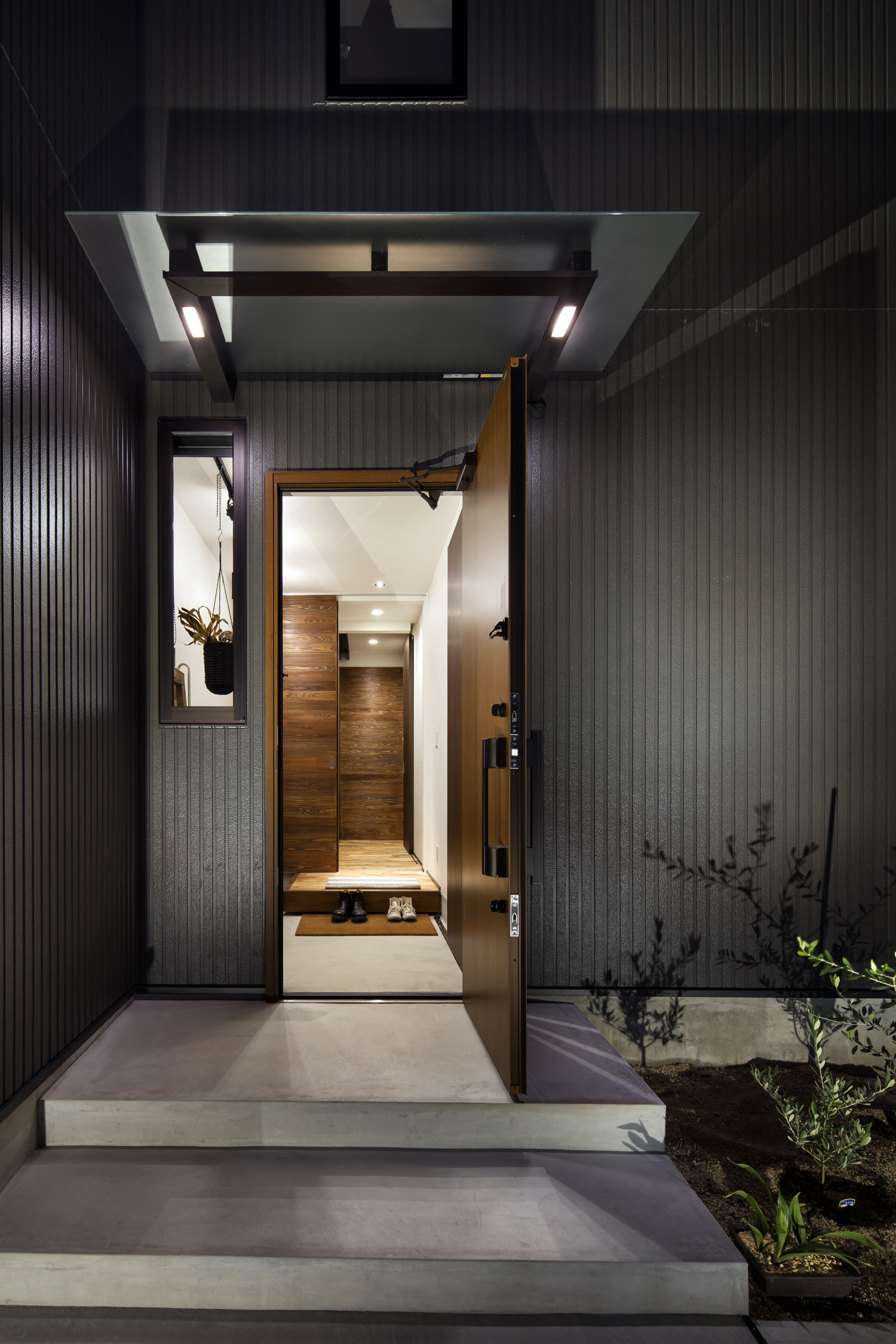 木製の玄関扉が開かれ室内が見える様子・デザイン住宅 注文住宅・デザイン住宅建築実例_『CASE610 Lagom hus ちょうどいい家』_外観