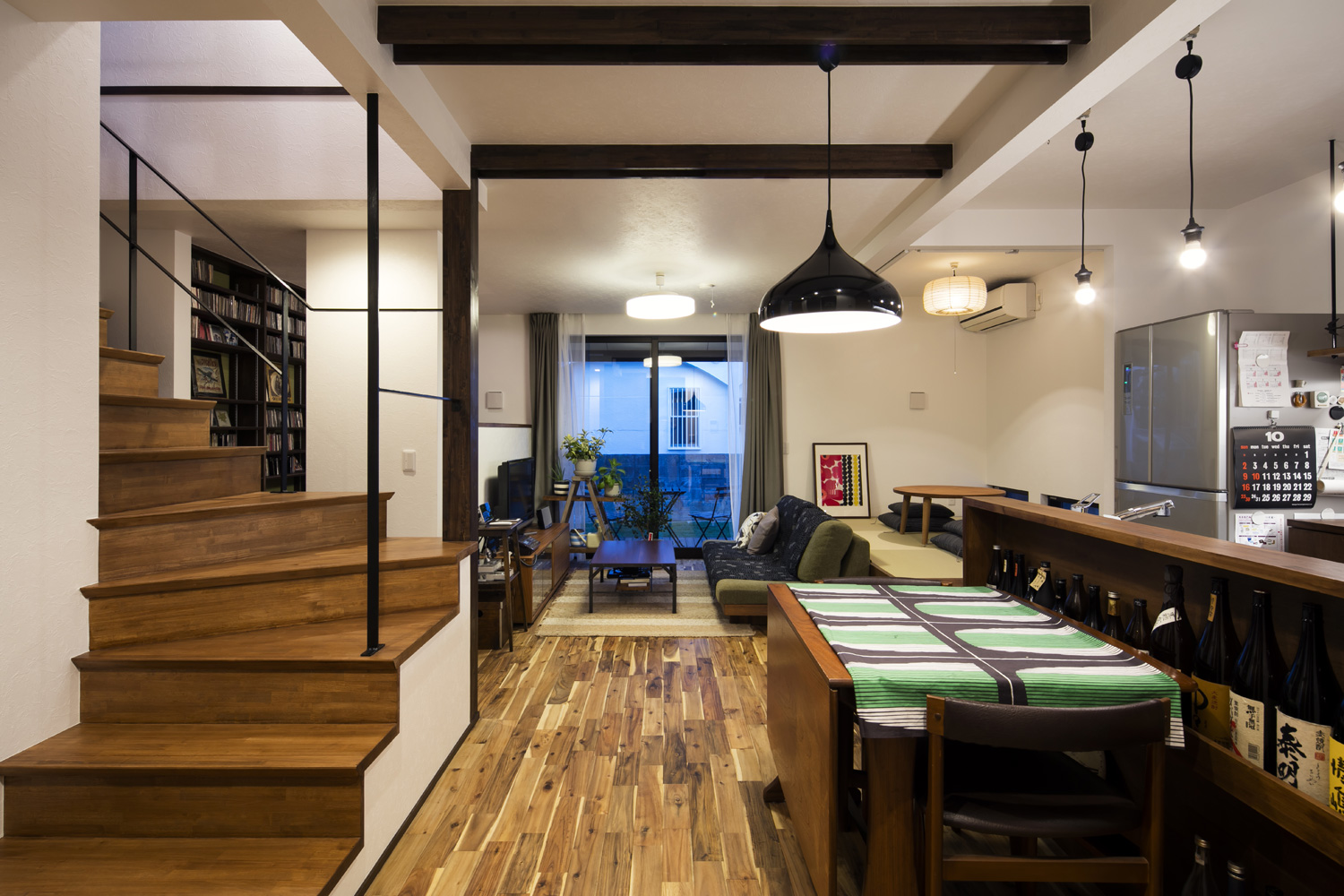 テラスに繋がる窓がある、ペンダントライトに照らされたLDK・デザイン住宅 注文住宅・デザイン住宅建築実例_『CASE610 Lagom hus ちょうどいい家』_LDK