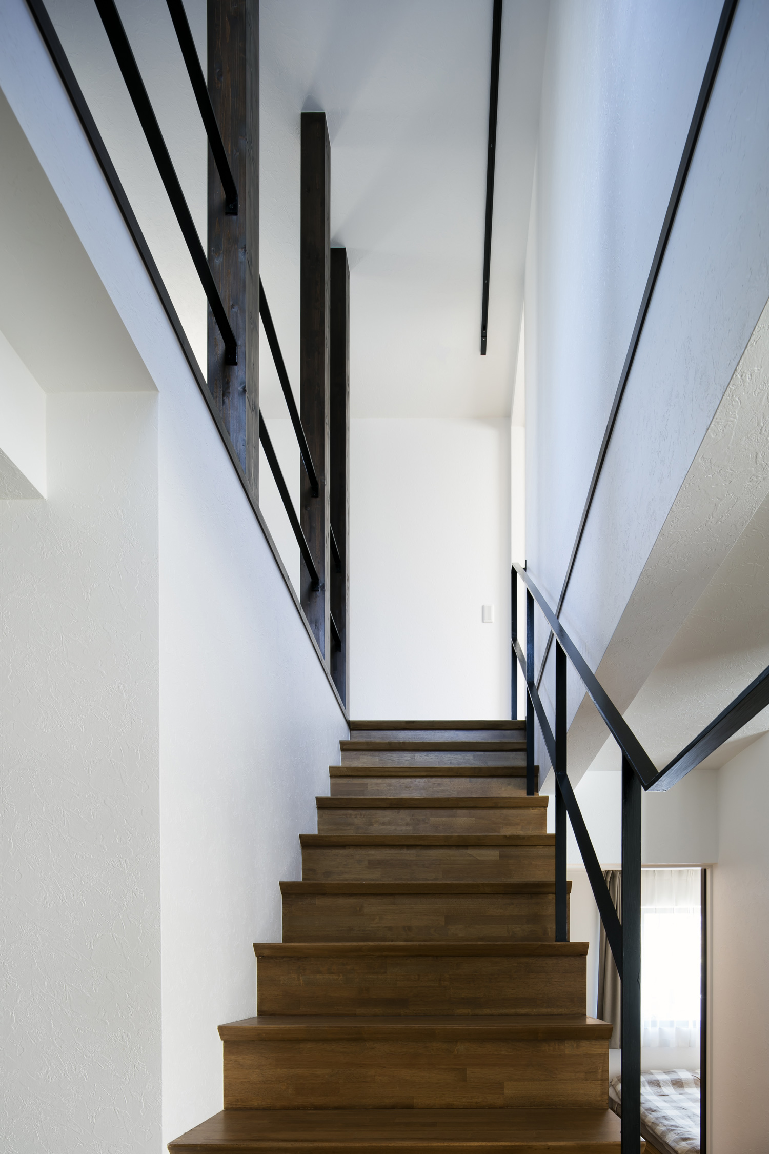 白い壁に付けられた、アイアンの手すりがある木製の箱型階段・デザイン住宅 注文住宅・デザイン住宅建築実例_『CASE610 Lagom hus ちょうどいい家』_階段