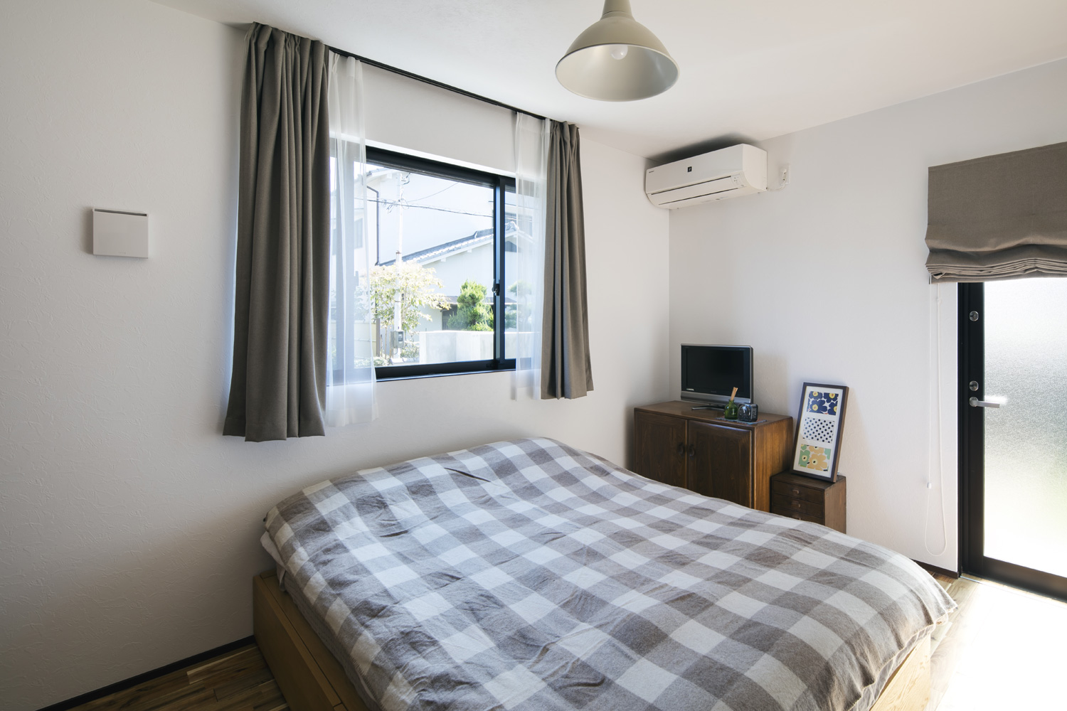 二方向に窓がある、チェック柄の毛布のベッドを置いた寝室・デザイン住宅 注文住宅・デザイン住宅建築実例_『CASE610 Lagom hus ちょうどいい家』_寝室