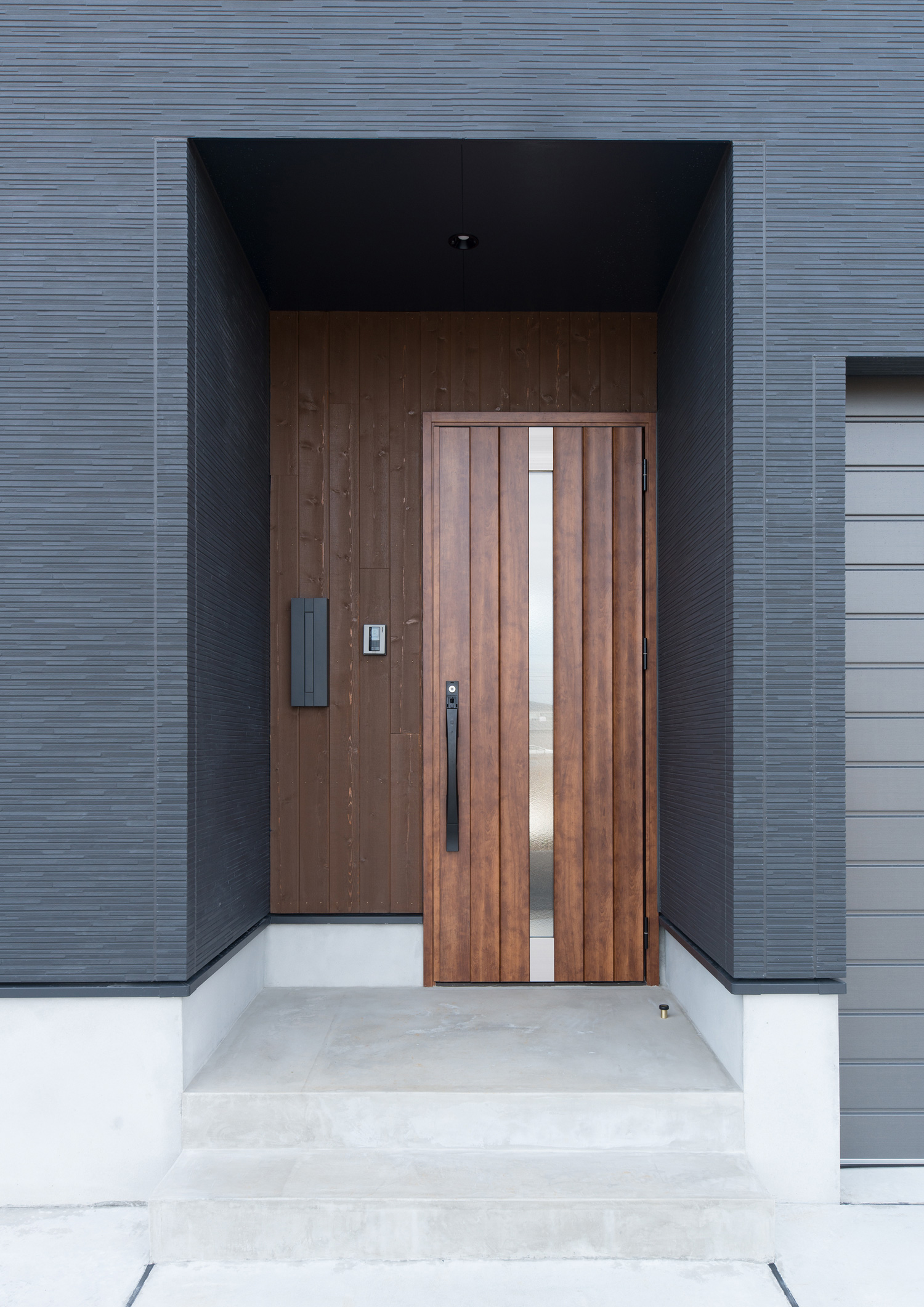 壁と扉が木材で統一された玄関ポーチ・デザイン住宅 注文住宅・デザイン住宅建築実例_『CASE611 黒曜×石英』_外観