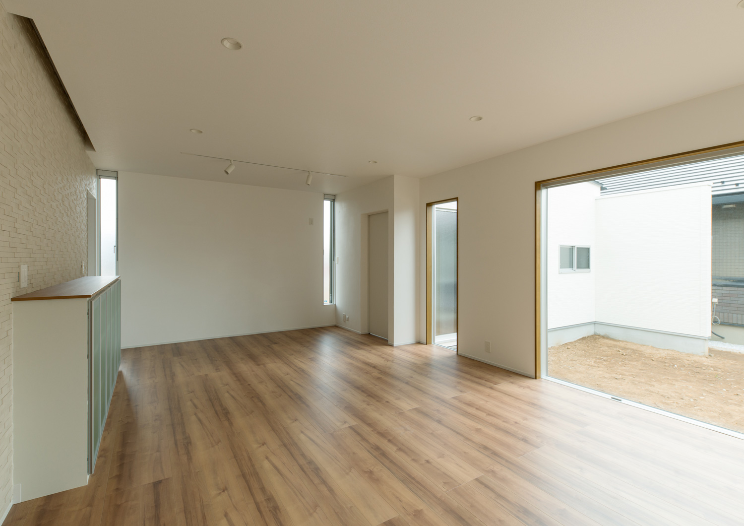 庭に面した大きな窓があるフローリングで白い壁のLDK・デザイン住宅 注文住宅・デザイン住宅建築実例_『CASE611 黒曜×石英』_LDK