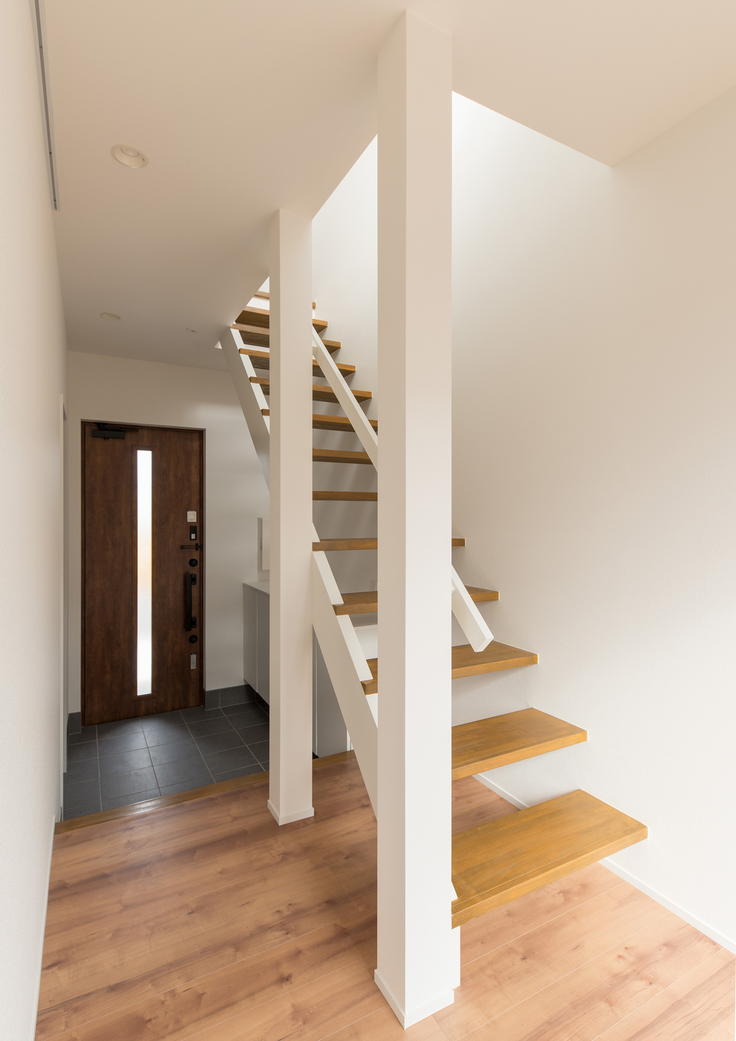 玄関の上を通るような木製のスケルトン階段・デザイン住宅 注文住宅・デザイン住宅建築実例_『CASE611 黒曜×石英』_階段