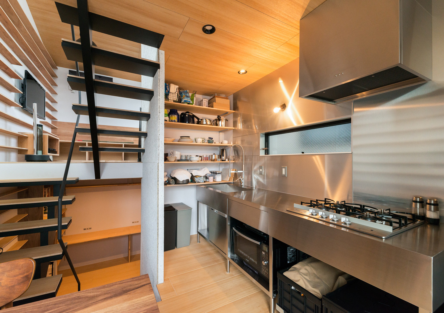 壁付けのステンレスのキッチンがあるスキップフロアのLDK・デザイン住宅 注文住宅・デザイン住宅建築実例_『CASE612 たなのいえ』_LDK