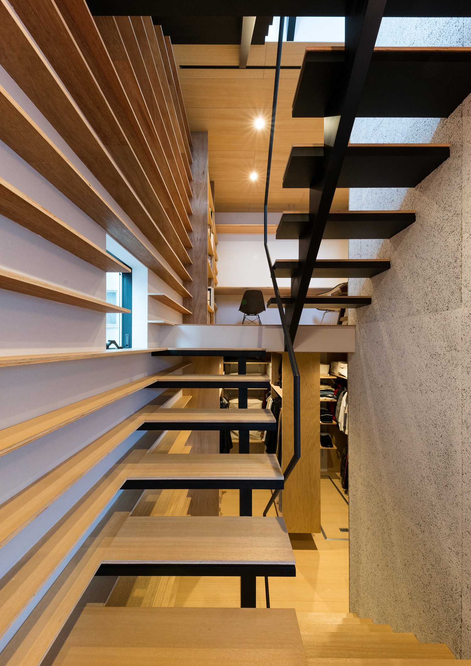 壁一面に取り付けられた棚と、木製のスケルトン階段が一体に見えるようなデザイン・デザイン住宅 注文住宅・デザイン住宅建築実例_『CASE612 たなのいえ』_階段