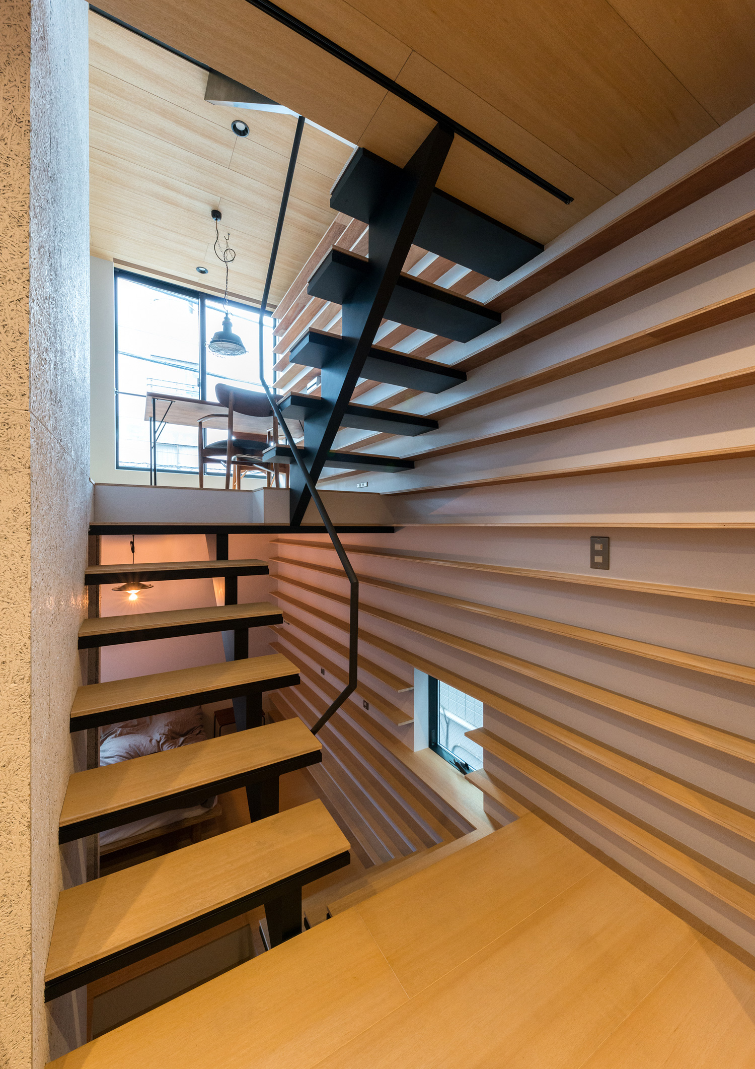 壁一面に木製の棚がある、スケルトン階段で繋がったスキップフロアのLDK・デザイン住宅 注文住宅・デザイン住宅建築実例_『CASE612 たなのいえ』_階段