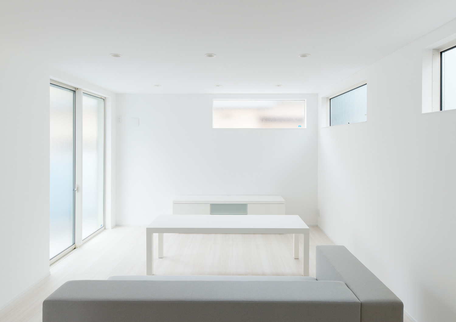 グレーのL字ソファーがある、白い壁に囲まれたLDK・デザイン住宅 注文住宅・デザイン住宅建築実例_『CASE613 Drop of ink』_LDK