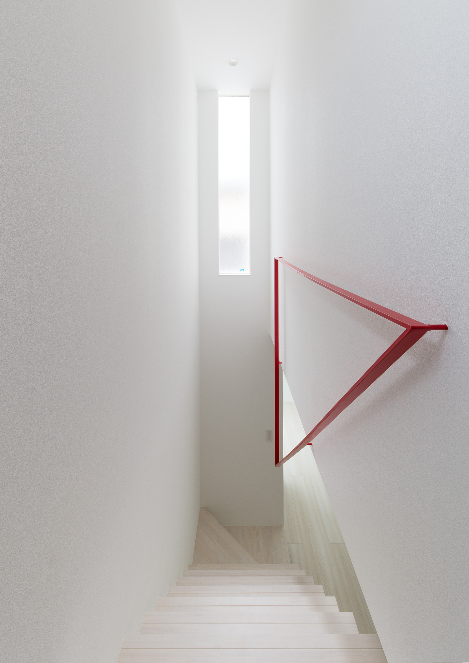 赤い三角形の手すりを壁に取り付け、天井近くに縦長のスリット窓がある階段部分・デザイン住宅 注文住宅・デザイン住宅建築実例_『CASE613 Drop of ink』_階段