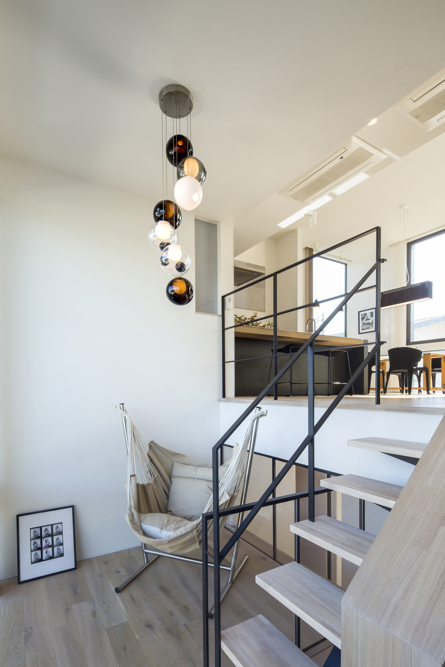 天井に丸いペンダントライトが取り付けられた、LDKの様子が見えるスキップフロア・デザイン住宅 注文住宅・デザイン住宅建築実例_『CASE614 『Skip』』_LDK