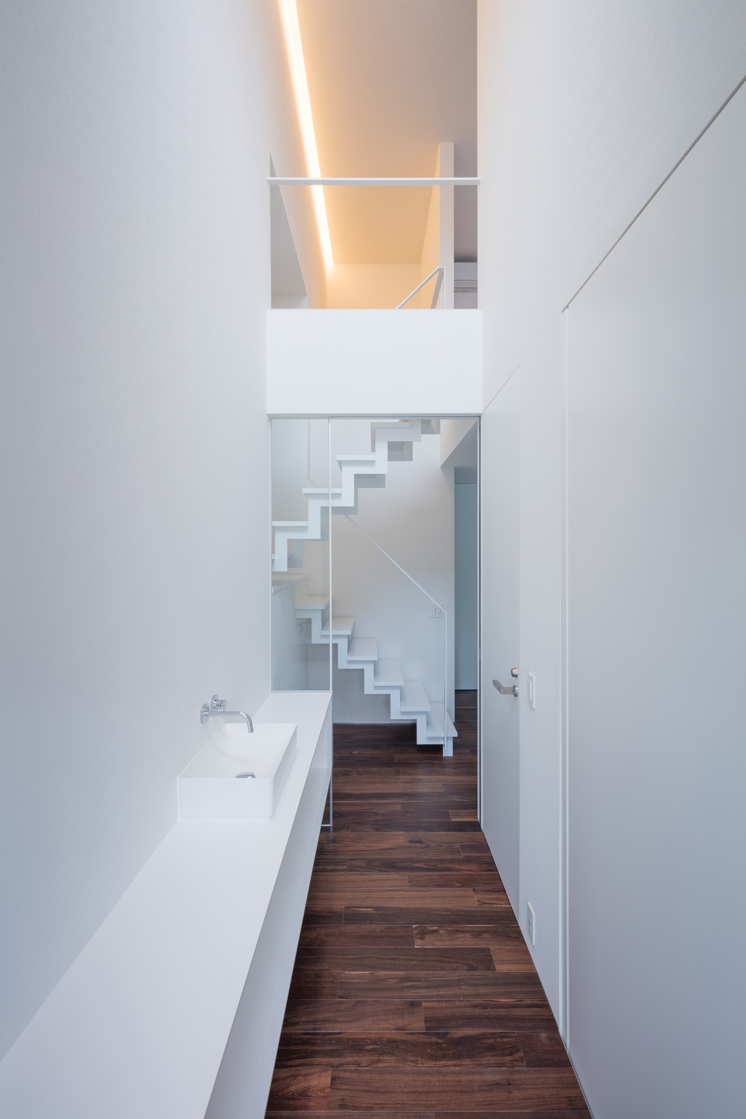 手洗いカウンターがあるフローリングの廊下の突き当りに、スケルトン階段がある様子・デザイン住宅 注文住宅・デザイン住宅建築実例_『CASE616 HOUSE.FLOAT』_玄関