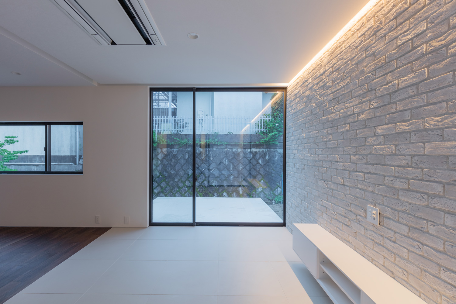 白いテラスに繋がる大開口窓がある、タイルのアクセントウォールを設けたLDK・デザイン住宅 注文住宅・デザイン住宅建築実例_『CASE616 HOUSE.FLOAT』_LDK