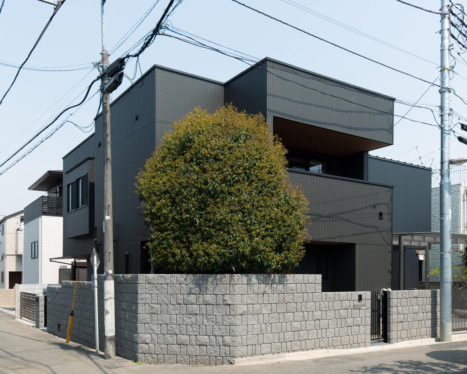 角に木が植えられている、角地に建つ黒い外壁の住宅・デザイン住宅 注文住宅・デザイン住宅建築実例_『CASE620 継承する家』_外観