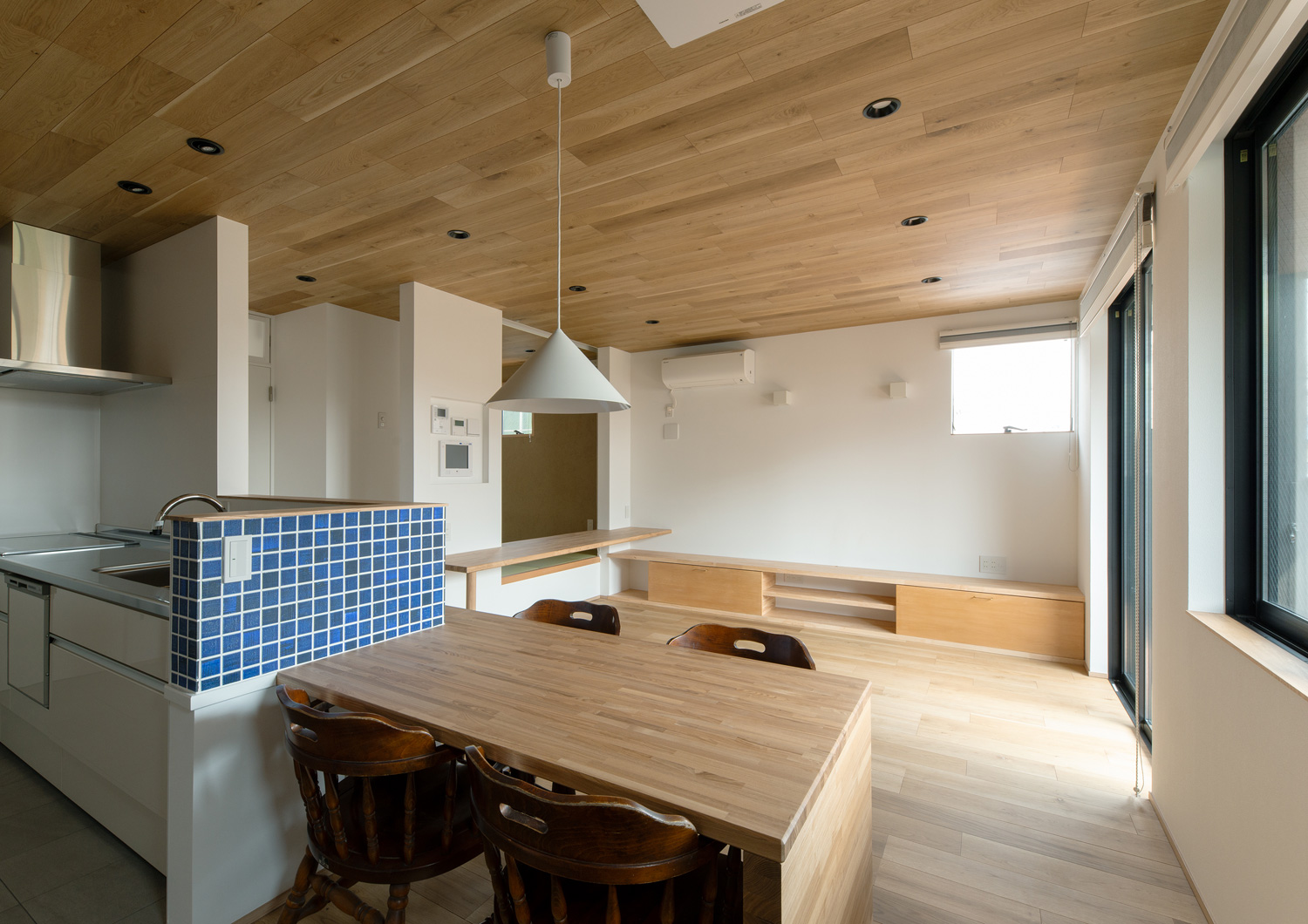腰壁付きのキッチンと横並びになった木製のダイニングテーブルがあるLDK・デザイン住宅 注文住宅・デザイン住宅建築実例_『CASE620 継承する家』_LDK