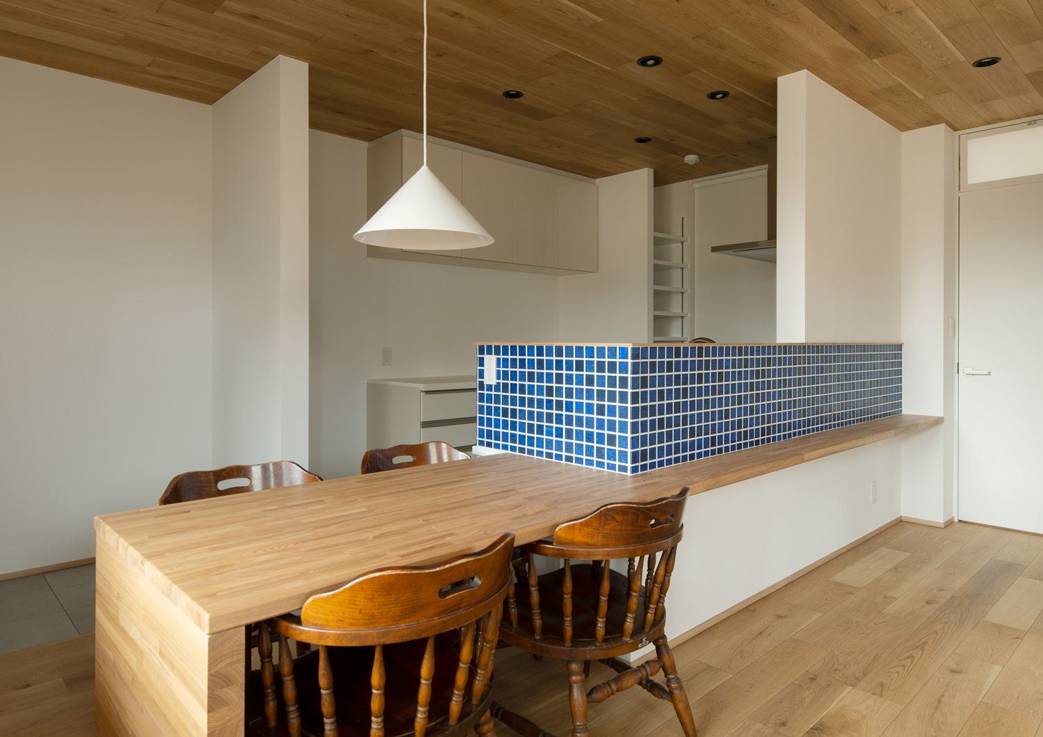 青いタイルの腰壁がついたキッチンと一体になった、木製のダイニングテーブル・デザイン住宅 注文住宅・デザイン住宅建築実例_『CASE620 継承する家』_LDK